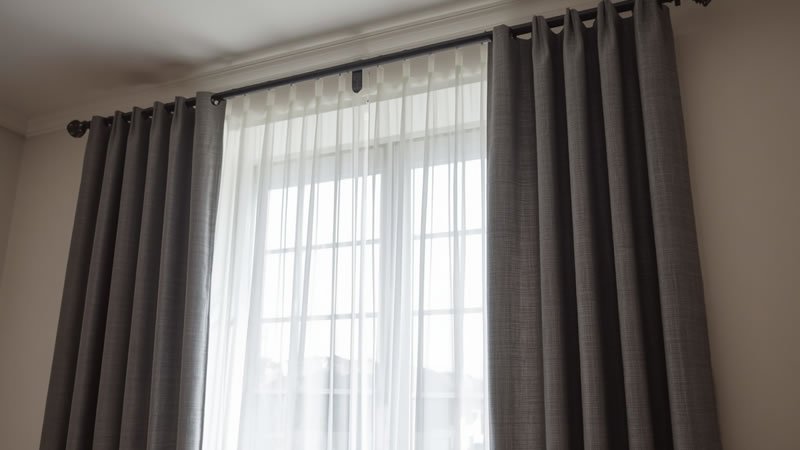 curtains for bedroom decor showing layered sheer and blackout panels on a double curtain rod